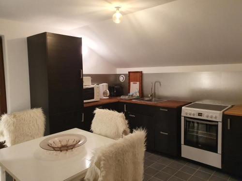 - une cuisine avec une table blanche, des chaises et un évier dans l'établissement Chalet Tante Emma, à Vacheresse