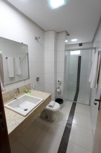a bathroom with a toilet and a sink and a shower at Golden Ville Hotel in Marabá