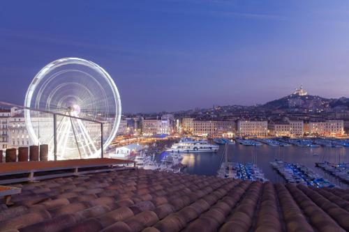 a ferris wheel on top of a building with a harbor at La Residence Du Vieux Port in Marseille