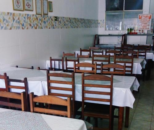 a row of tables and chairs in a restaurant at Pousada Brasil - Self Check-in in Aparecida