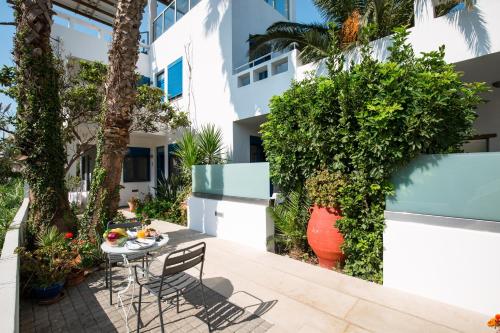 a patio with a table and chairs in front of a building at Anna Plakias Apartments in Plakias