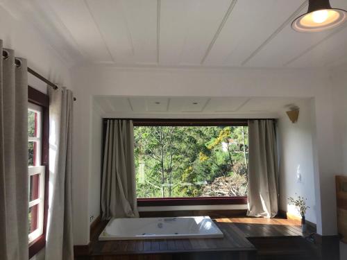 a bathroom with a tub and a large window at Hotel Recanto do Ouro in Ouro Preto