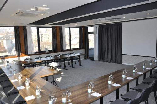 a meeting room with long tables and chairs at Hotel President Sarajevo in Sarajevo