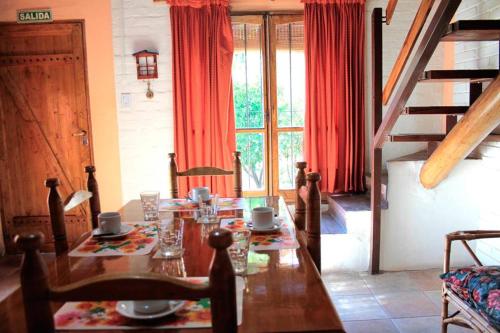 a dining room with a table and red curtains at Cabañas Calderón I in San Rafael