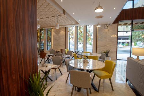 a restaurant with tables and chairs and windows at mawasim al hay at hotel in Jeddah
