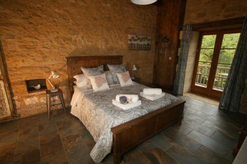 een slaapkamer met een bed in een kamer bij La Roussille - Oak Barn in Saint-Sulpice-dʼExcideuil