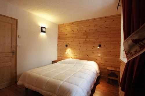 een slaapkamer met een wit bed in een houten muur bij Les Cabasses 6 - Accommodation in a village house in Villar-dʼArène