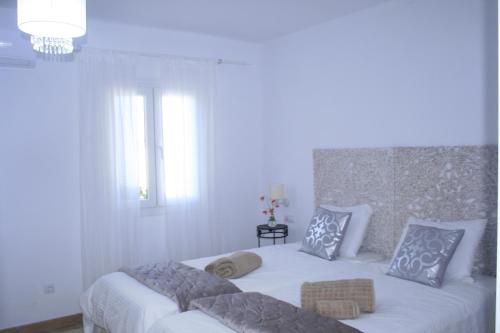 ein weißes Schlafzimmer mit einem Bett mit zwei Kissen in der Unterkunft SWEET HOUSE in Santa Margalida