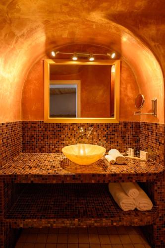 a bathroom with a sink and a mirror at Above Blue Suites in Imerovigli