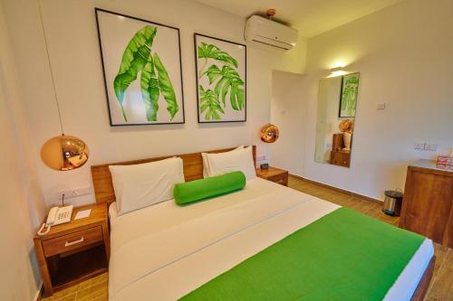 a bedroom with a bed with a green pillow on it at Agnus Unawatuna in Unawatuna