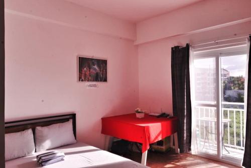 a bedroom with a red desk and a red table at ANIA CONDO STAY in Mactan