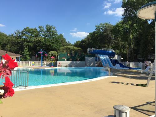 une grande piscine avec un toboggan aquatique dans l'établissement Mobilhome familial 6 à 7 p 3 chambres 42 m2 Saint Brévin Les Pierres Couchées, à Saint-Brévin-les-Pins