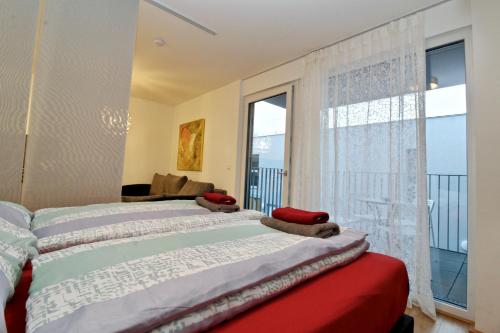 Un dormitorio con una cama y una ventana grande. en Balcony/pool/free parking garage Studio, en Viena