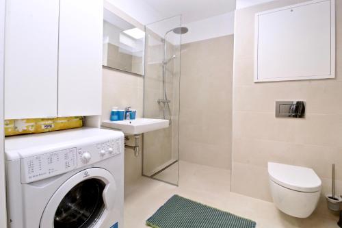 Un baño con lavadora y lavabo. en Balcony/pool/free parking garage Studio, en Viena
