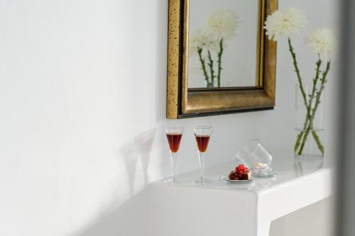 two glasses of wine sitting on a white shelf at Above Blue Suites in Imerovigli