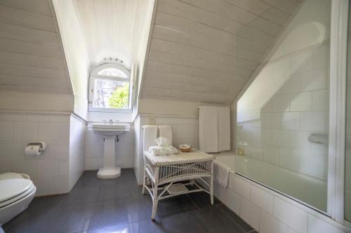 a white bathroom with a sink and a toilet at Estancia Ave María in Tandil