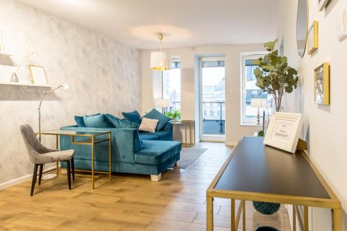 a living room with a blue couch and a table at Space Apartments Szczecin in Szczecin