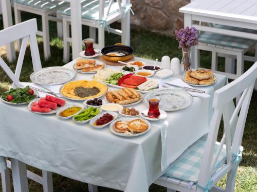 ein weißer Tisch mit einem Buffet mit Speisen drauf in der Unterkunft Bi Salkım Bozcaada Otel in Bozcaada