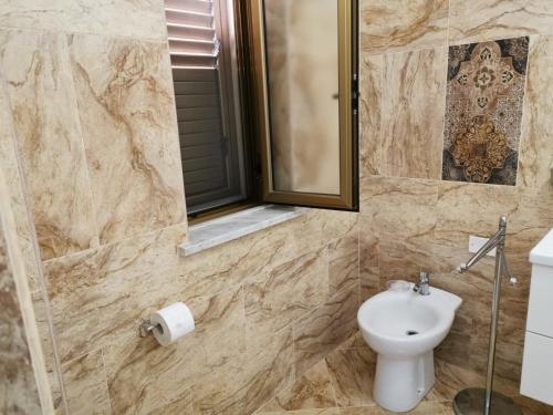 ein Badezimmer mit einem WC, einem Waschbecken und einem Spiegel in der Unterkunft IL FEUDO in Sellia Marina