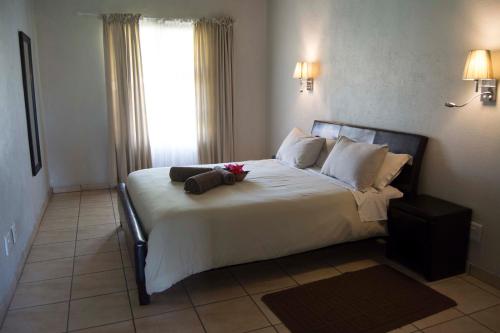 a bedroom with a large bed with white sheets and pillows at Floreat Riverside Lodge and Spa in Sabie