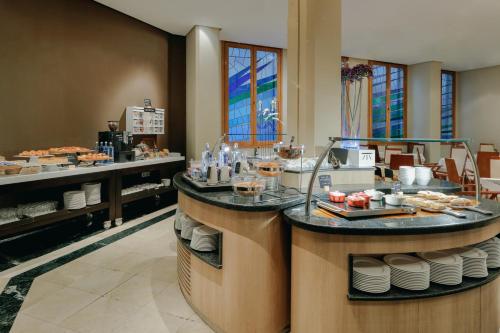 a restaurant with a counter with food on it at Hesperia Zaragoza Centro in Zaragoza
