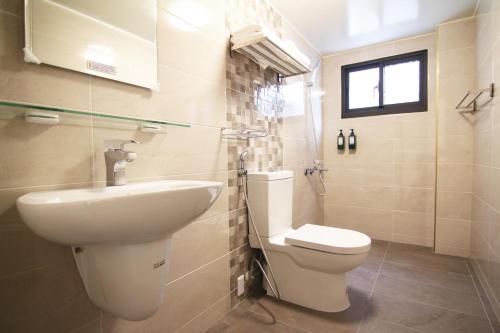 a bathroom with a toilet and a sink at Haichin&Haiting B&B in Donggang