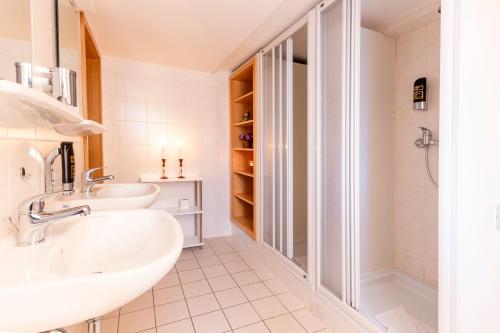 Waldgasthof Bad Einsiedel في زايفن: حمام مع مغسلتين ودش