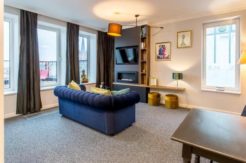 a living room with a blue couch and a table at Space Apartments Szczecin in Szczecin