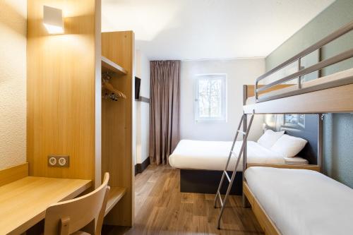 een hotelkamer met 2 bedden en een bureau bij B&B HOTEL Saint-Michel sur Orge in Saint-Michel-sur-Orge