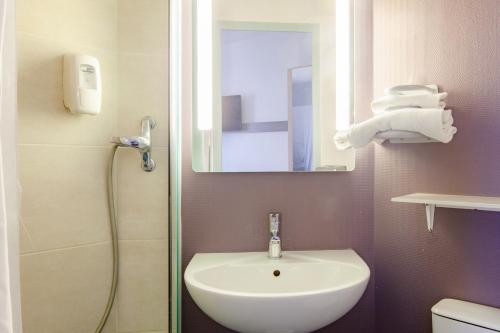W łazience znajduje się umywalka oraz prysznic z lustrem. w obiekcie B&B HOTEL Saint-Michel sur Orge w mieście Saint-Michel-sur-Orge