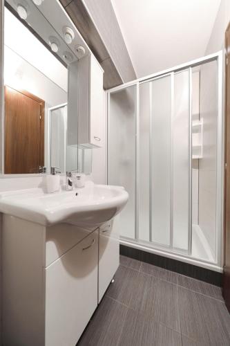 a white bathroom with a sink and a shower at Villa Bobic in Kraj
