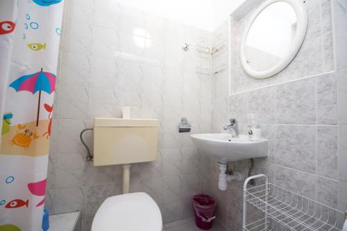 łazienka z umywalką, toaletą i lustrem w obiekcie Studios Lavender w Splicie