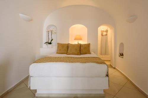 a white bedroom with a bed in a room at Above Blue Suites in Imerovigli