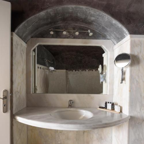 a bathroom with a sink and a mirror at Above Blue Suites in Imerovigli