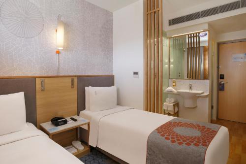 a hotel room with two beds and a bathroom at Holiday Inn Express Hyderabad Banjara Hills by IHG in Hyderabad