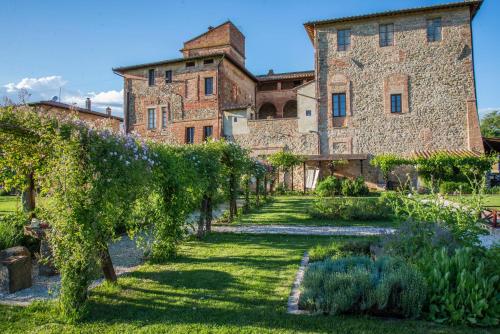 a garden in front of a large stone building at Abbazia Sette Frati Agriturismo Fratres in Pietrafitta