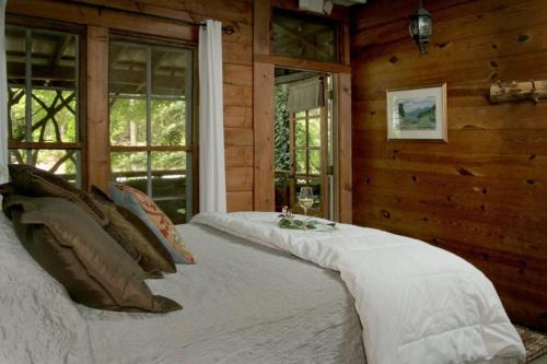 a large bed in a room with wooden walls at Lake Rabun Hotel in Lakemont