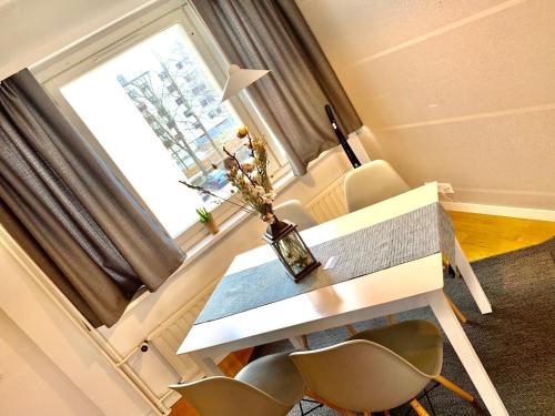 une chambre avec une table, des chaises et une fenêtre dans l'établissement DP Apartments Vaasa II, à Vaasa