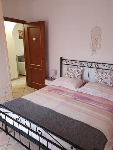 a bedroom with a large bed with a metal frame at Mary House in Ladispoli