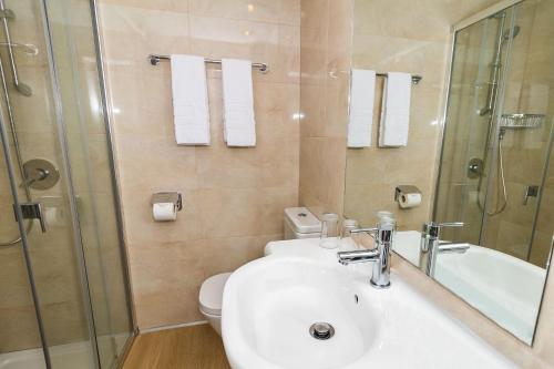 a bathroom with a sink and a shower and a toilet at Eix Alcudia Hotel in Port d'Alcudia