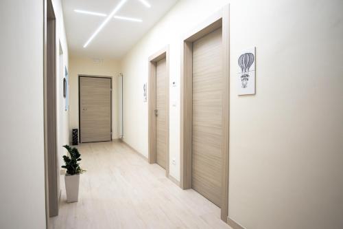 un pasillo con puertas y una planta en una habitación en Villa Joy - Iconic Heritage Rooms, en Montesilvano