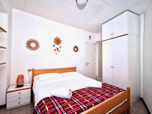a bedroom with a bed with a red and white blanket at MARINA BAY by Design Studio in Bellano