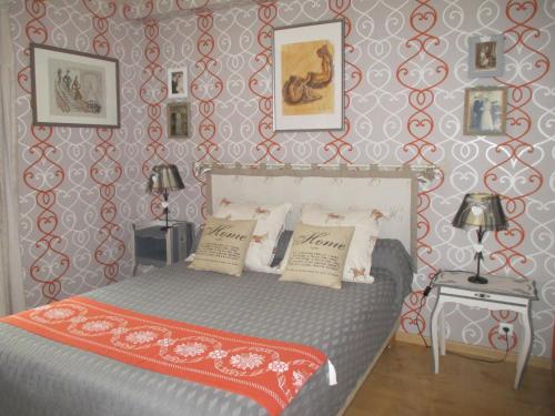 a bedroom with a bed and a red and white patterned wall at La Clé Des Champs in Villiers-les-Hauts