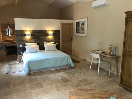 une chambre avec un lit, une table et un bureau dans l'établissement Mas Li Doumenge, à Orange