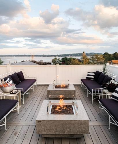 a patio with couches and a fire pit on a deck at The Menhaden Hotel in Greenport