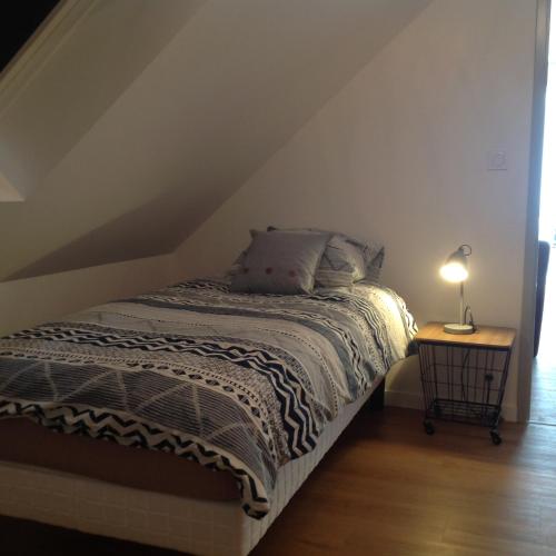 une chambre avec un lit et une table avec une lampe dans l'établissement Au Bord Du Chenal, à Porspoder