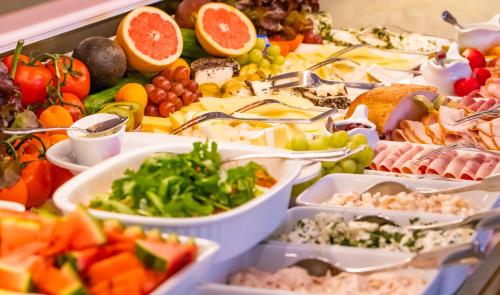 een buffet met veel verschillende soorten eten op dienbladen bij La Maison M in Westerland