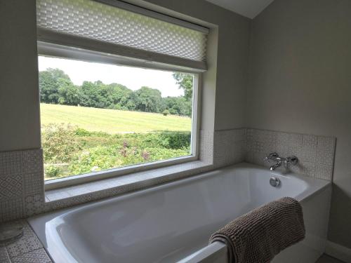 Snaffles في رويال تونبريدج ويلز: حوض استحمام في الحمام مع نافذة