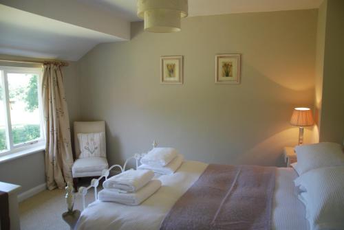 a white bedroom with a bed and a window at Snaffles in Royal Tunbridge Wells