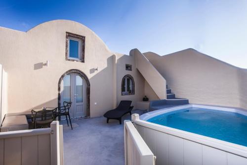 a villa with a swimming pool and a house at Cupola Suites in Oia